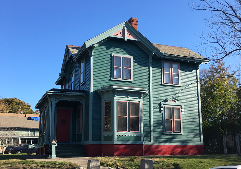 Finished painted house with green siding and red detailed trim